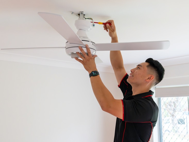 Technician installing a ceiling fan.