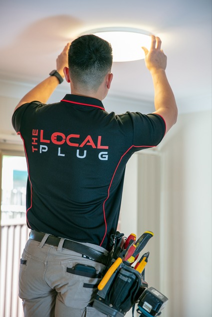 Electrician installing ceiling light.