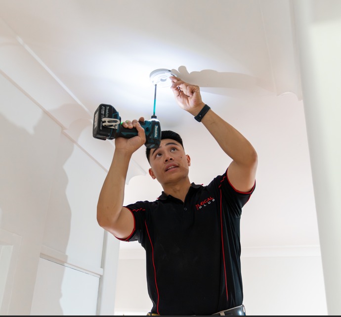 Electrician installing smoke alarm.