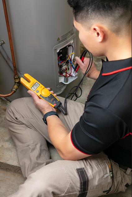 Technician testing water heater wiring.