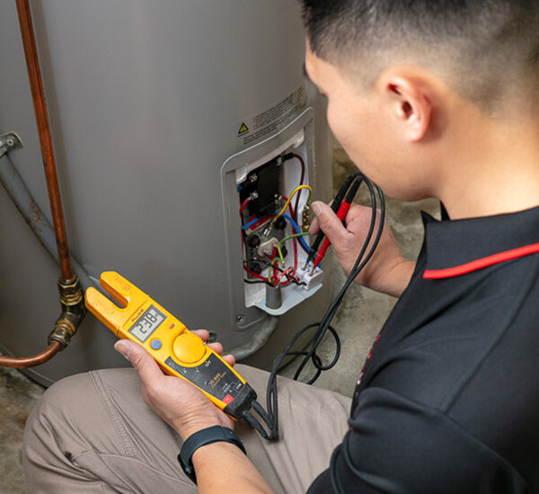 electrician testing wiring during hot water system installation